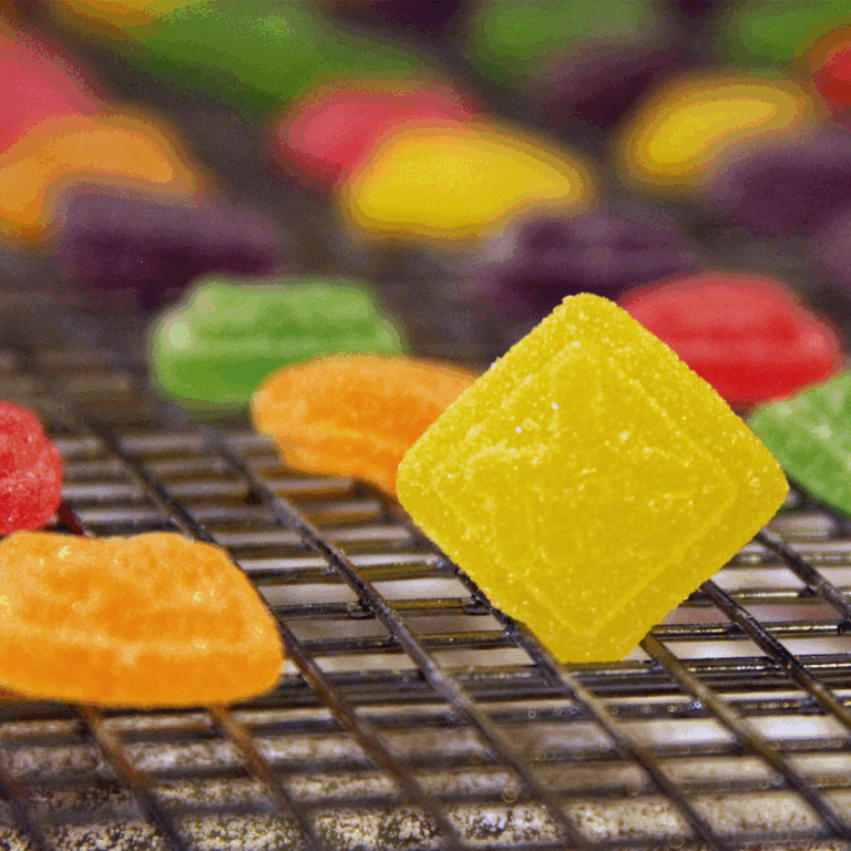 Close-up image of square cannabis gummies in yellow, green, orange, purple, and red.